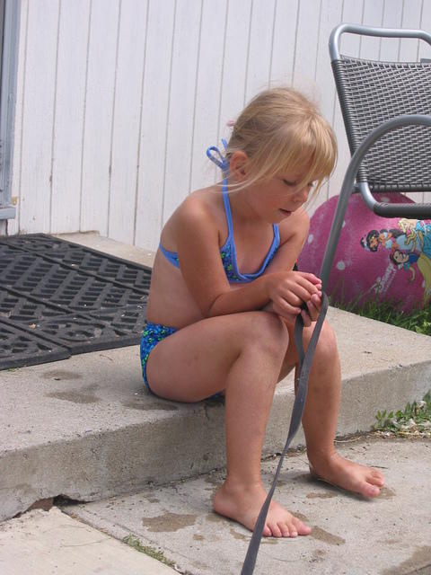 Carrie sitting on the step, holding Ebbie's leash.