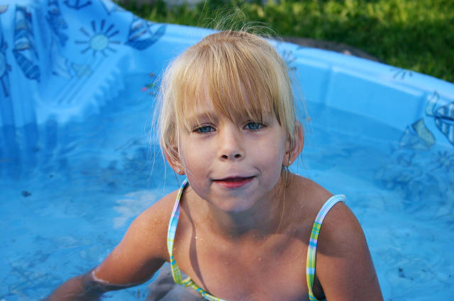 Carrie playing in her little wading pool (with the dogs)