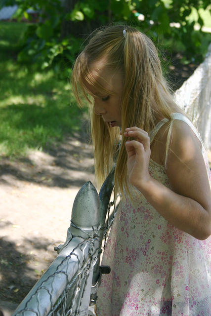 Carrie looking at a bug on a fence