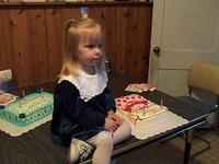 Mom insists Carrie must sit on the table with the cakes for a photo shoot.