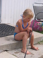 Carrie sitting on the step, holding Ebbie's leash.